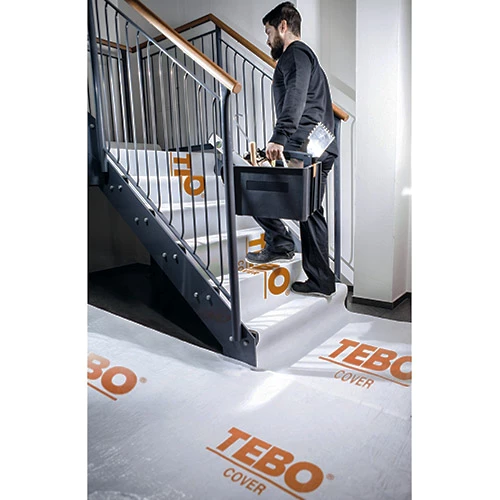 Golvskydd nonwowen 0,8X25m med självhäftande baksida på arbetsplats.