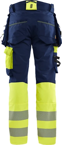 Blåkläder Hantverksbyxa i marinblå och varselgul med reflexer nedtill, sedd bakifrån.
